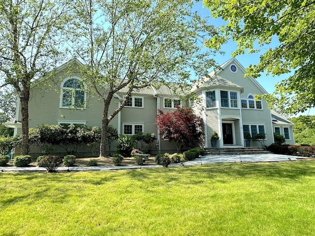 rear view of property featuring a lawn