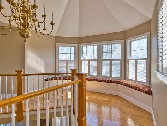 interior space with light hardwood / wood-style floors, an inviting chandelier, and lofted ceiling