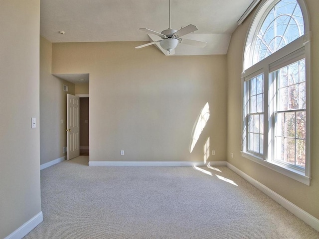 carpeted spare room featuring ceiling fan and vaulted ceiling