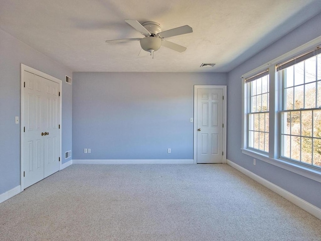 carpeted spare room featuring ceiling fan