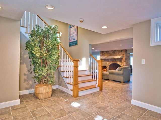 stairs with tile patterned flooring and a fireplace