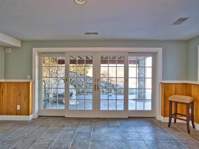 doorway to outside with wood walls and french doors