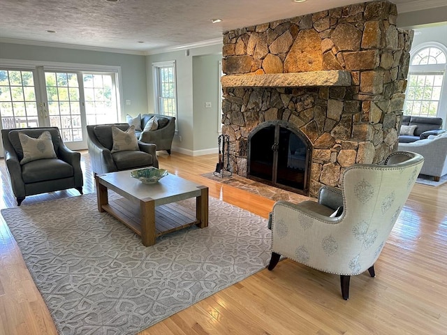 living room with a fireplace, light hardwood / wood-style flooring, a wealth of natural light, and ornamental molding