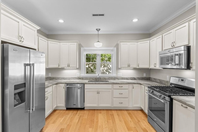 4 Emerald Way Unit 4, Salisbury, MA 01952 - kitchen featuring appliances with stainless steel finishes, white cabinets, crown molding, light stone countertops, and light wood-style floors