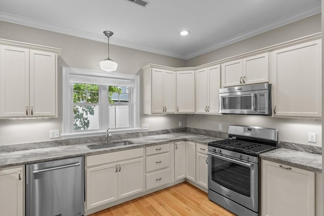 4 Emerald Way Unit 4, Salisbury, MA 01952 - kitchen featuring stainless steel appliances, white cabinets, light wood finished floors, hanging light fixtures, and crown molding