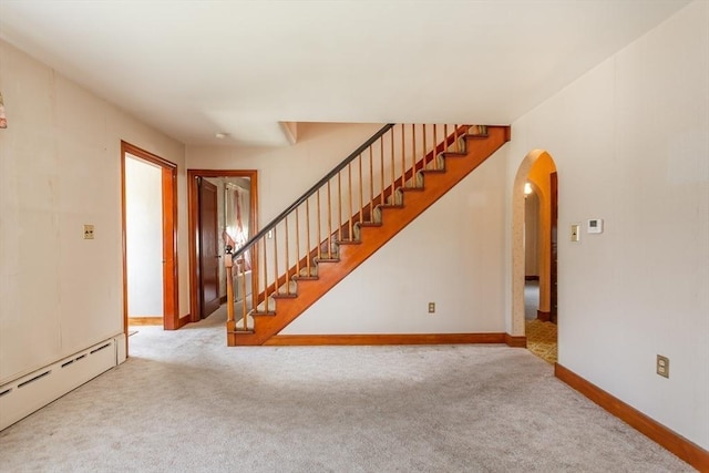 195 Hooper St, Tiverton, RI 02878 - unfurnished living room featuring a baseboard heating unit, arched walkways, carpet flooring, and stairs