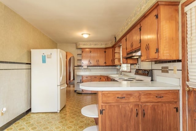 195 Hooper St, Tiverton, RI 02878 - kitchen with freestanding refrigerator, under cabinet range hood, light countertops, a peninsula, and a sink