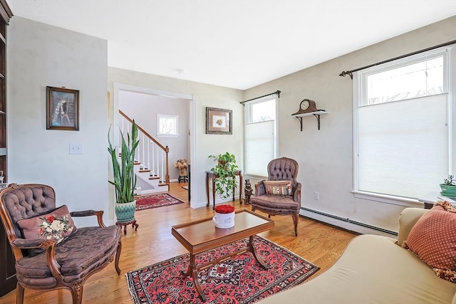 living room with stairs, wood finished floors, and a baseboard radiator