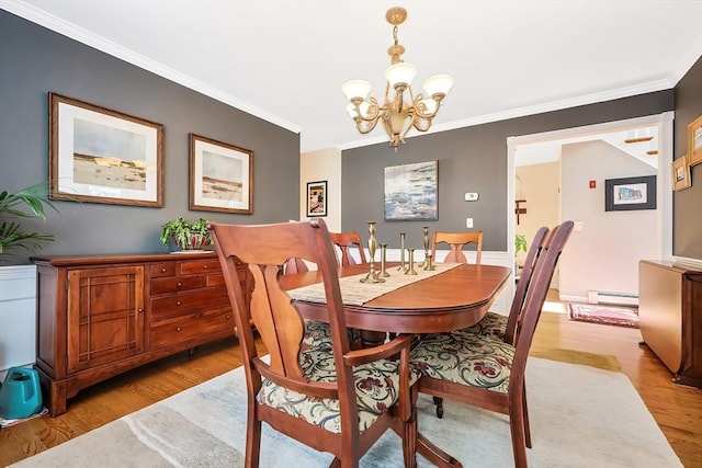 dining space featuring baseboard heating, a chandelier, crown molding, and light wood finished floors