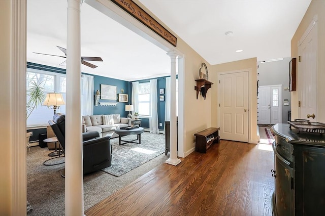 entrance foyer with baseboards, wood finished floors, a ceiling fan, and decorative columns