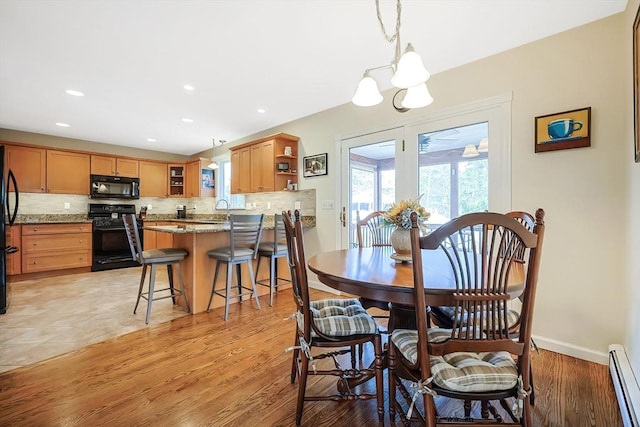 dining space featuring baseboard heating, recessed lighting, light wood-type flooring, and baseboards