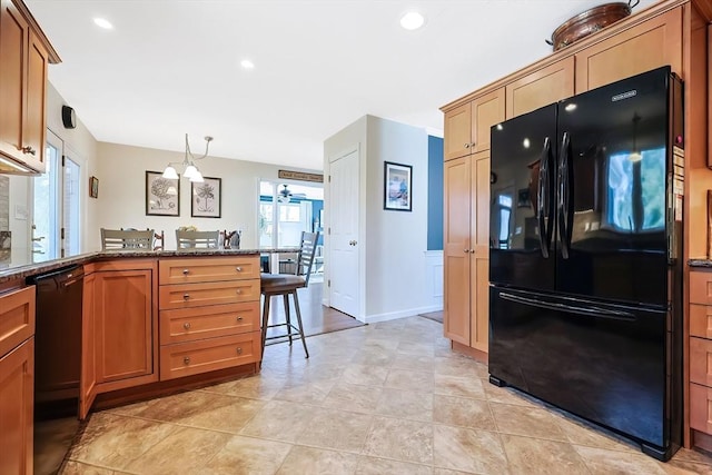 kitchen featuring a breakfast bar, recessed lighting, dark stone countertops, a peninsula, and black appliances