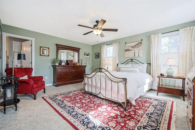 bedroom with a ceiling fan, baseboards, and light carpet