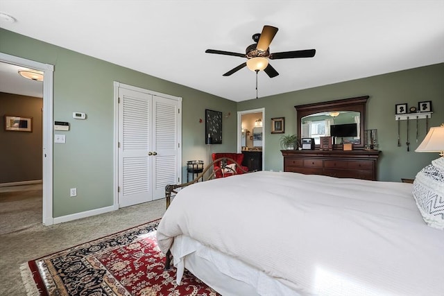 bedroom featuring a ceiling fan, a closet, connected bathroom, carpet, and baseboards