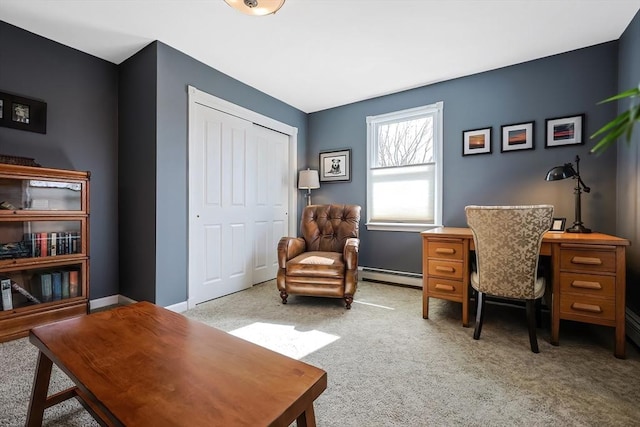 office space with a baseboard heating unit, light colored carpet, and baseboards