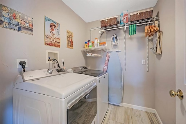 laundry area featuring washer and dryer, light wood-type flooring, baseboards, and laundry area