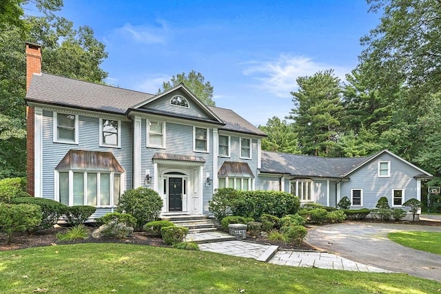 view of front of home featuring a front yard and a chimney