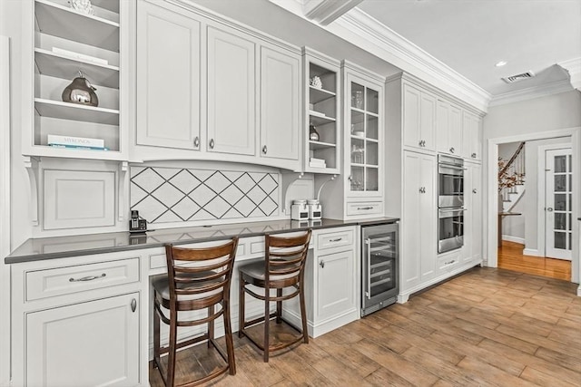 kitchen featuring beverage cooler, crown molding, light wood finished floors, and open shelves