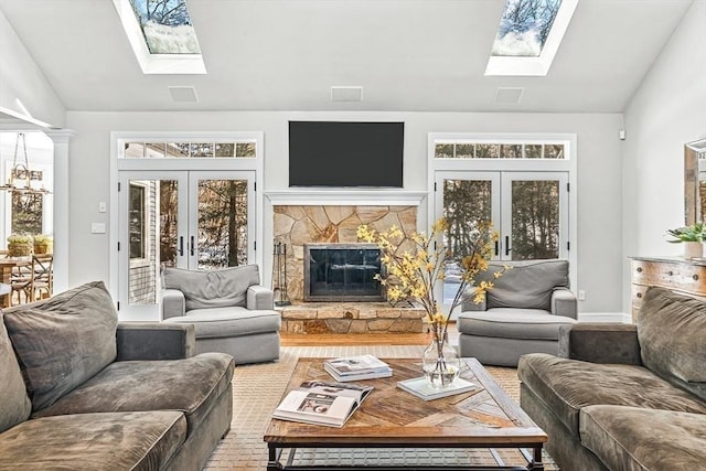 living area featuring lofted ceiling with skylight, a wealth of natural light, and french doors