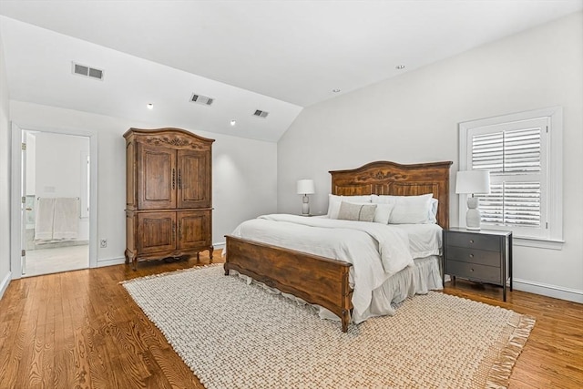 bedroom with lofted ceiling, baseboards, visible vents, and wood finished floors