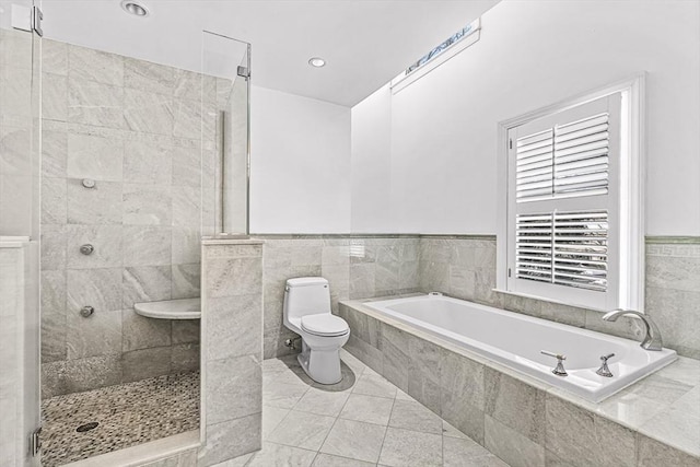 full bath with toilet, tile walls, a bath, tile patterned floors, and a stall shower