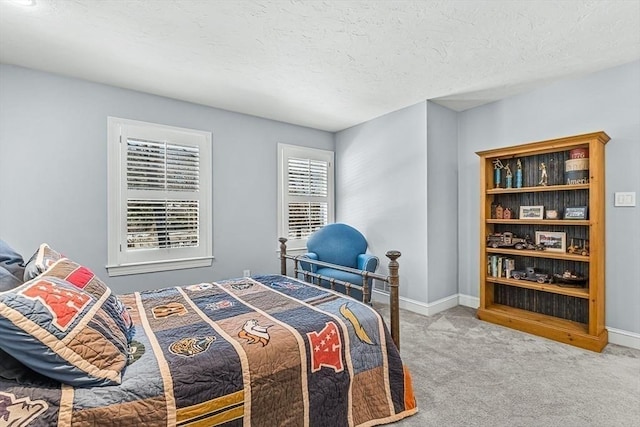 carpeted bedroom featuring baseboards and a textured ceiling