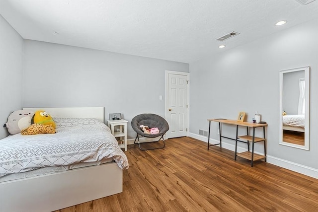 bedroom with recessed lighting, wood finished floors, visible vents, and baseboards