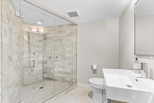 bathroom featuring a stall shower, baseboards, visible vents, toilet, and vanity