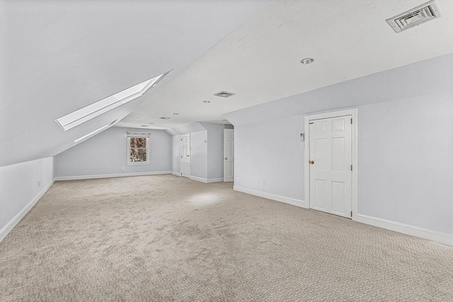 bonus room with baseboards, lofted ceiling with skylight, visible vents, and light colored carpet