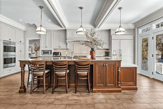 kitchen featuring a large island, backsplash, a sink, and built in appliances