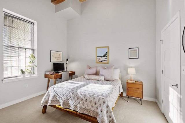 bedroom featuring baseboards and light colored carpet