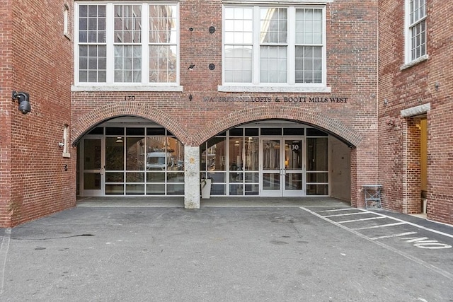 view of exterior entry with brick siding and french doors