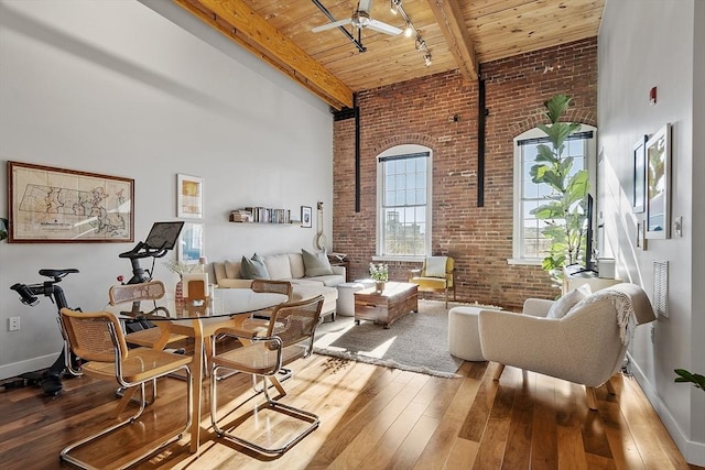 living area featuring wood-type flooring, brick wall, wood ceiling, and a high ceiling