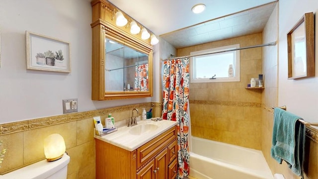 full bath featuring tile walls, shower / bath combination with curtain, vanity, and toilet