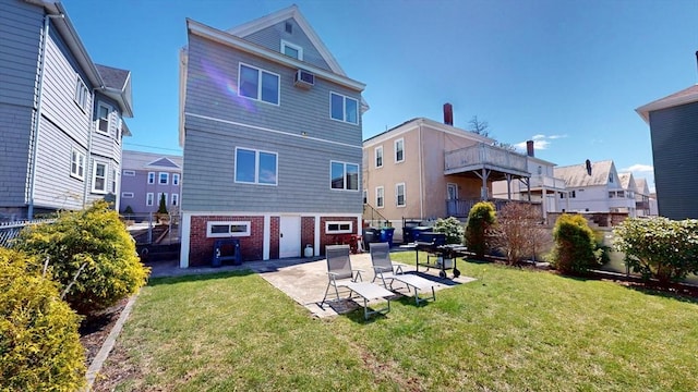 back of property with a patio, a yard, brick siding, and a wall unit AC