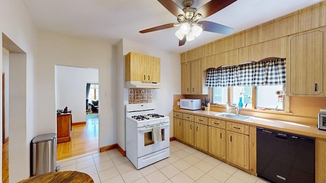 kitchen featuring white appliances, under cabinet range hood, a sink, light countertops, and a ceiling fan