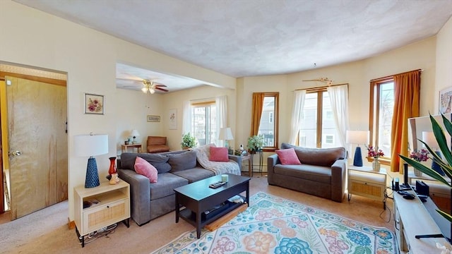 living area featuring light carpet and a ceiling fan