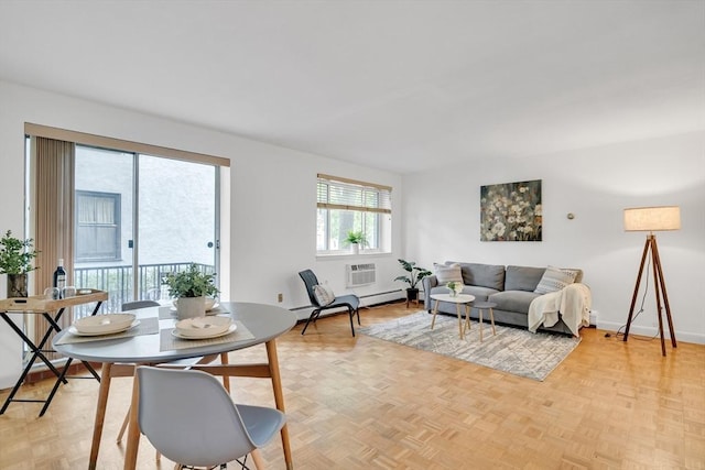 living room featuring light parquet flooring, baseboard heating, and a wall mounted AC