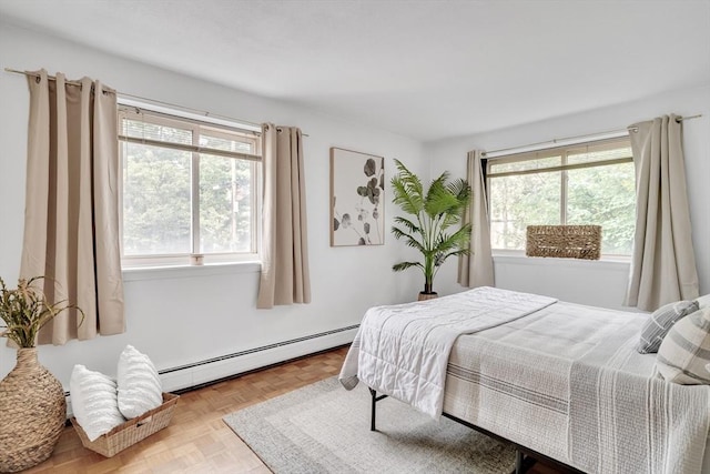 bedroom featuring light parquet floors and a baseboard heating unit