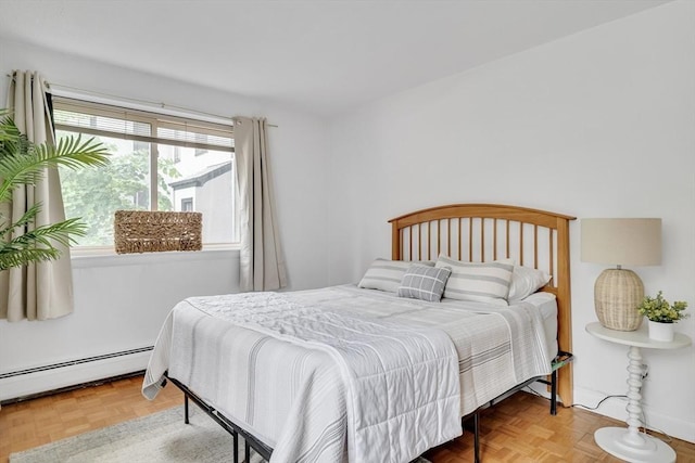 bedroom with a baseboard heating unit and parquet flooring