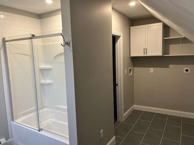 clothes washing area with hookup for an electric dryer, dark tile patterned floors, a textured ceiling, and hookup for a washing machine