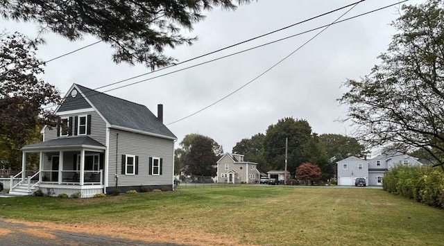 view of side of home featuring a lawn and covered porch