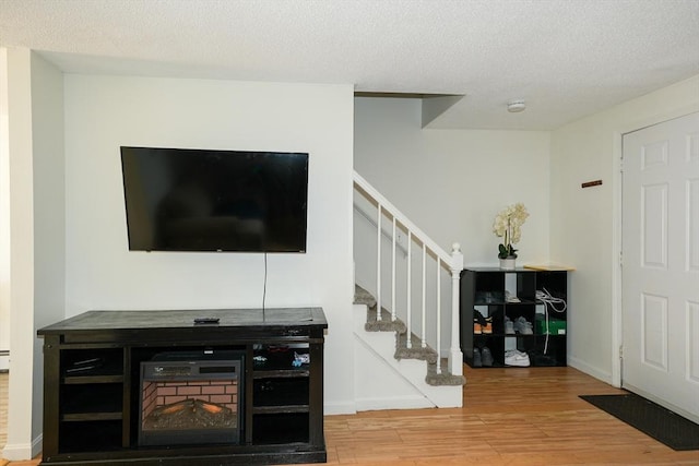 25 Sutherland St, Lowell, MA 01850 - living area featuring wood finished floors, stairway, and a textured ceiling