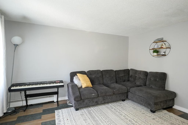 25 Sutherland St, Lowell, MA 01850 - living area featuring wood finished floors, a baseboard radiator, and a textured ceiling