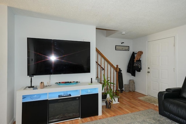 25 Sutherland St, Lowell, MA 01850 - living room featuring light wood finished floors, stairs, and a textured ceiling