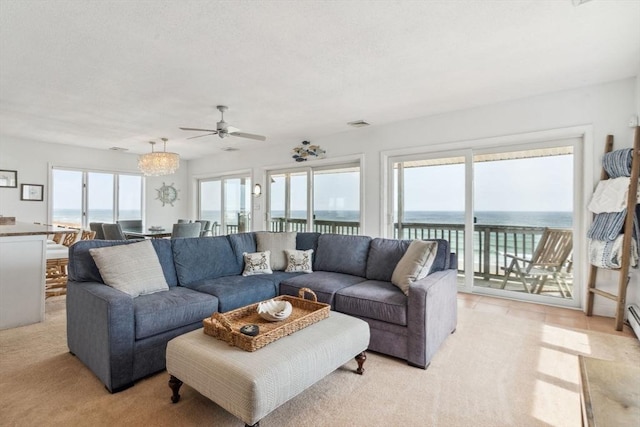 living area featuring a ceiling fan, a water view, and light carpet