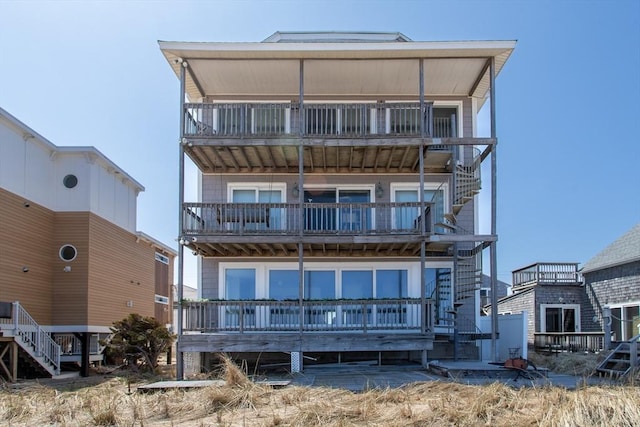 back of property featuring a balcony and stairs