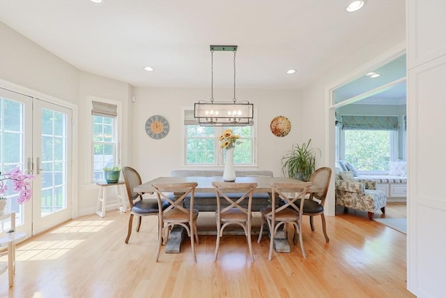 dining area with healthy amount of natural light, light wood finished floors, recessed lighting, and french doors