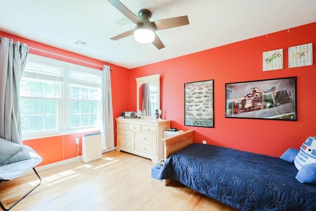 bedroom with wood finished floors, a ceiling fan, and baseboards