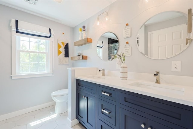full bathroom with baseboards, toilet, double vanity, and tile patterned flooring